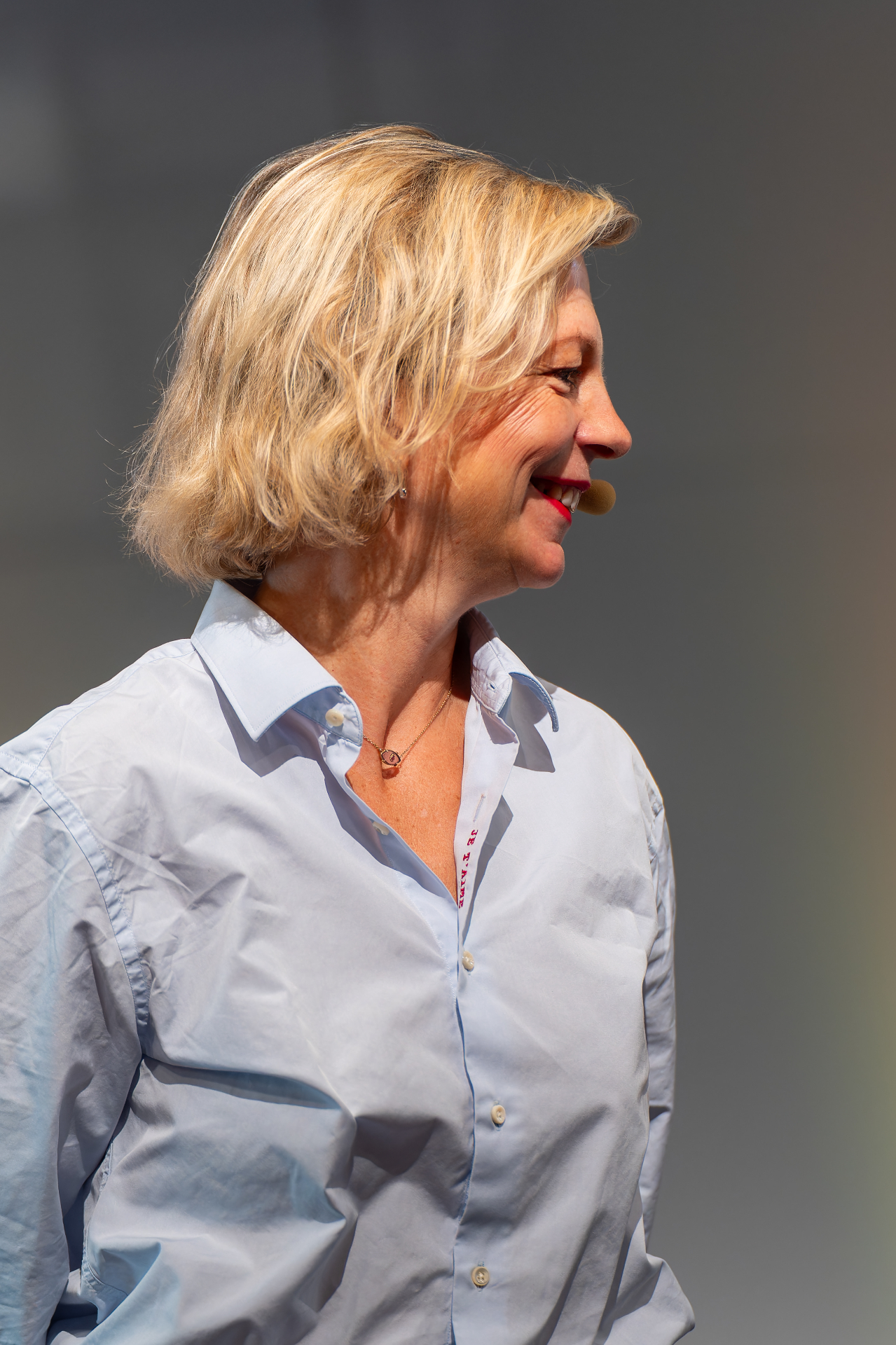 Delphine Zanelli de profil, souriante, chemise bleu clair, lors d'un séminaire managers